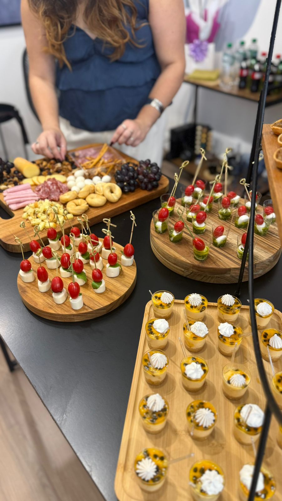 Mesa de finger foods com tábuas de frios, caprese e mini sobremesas